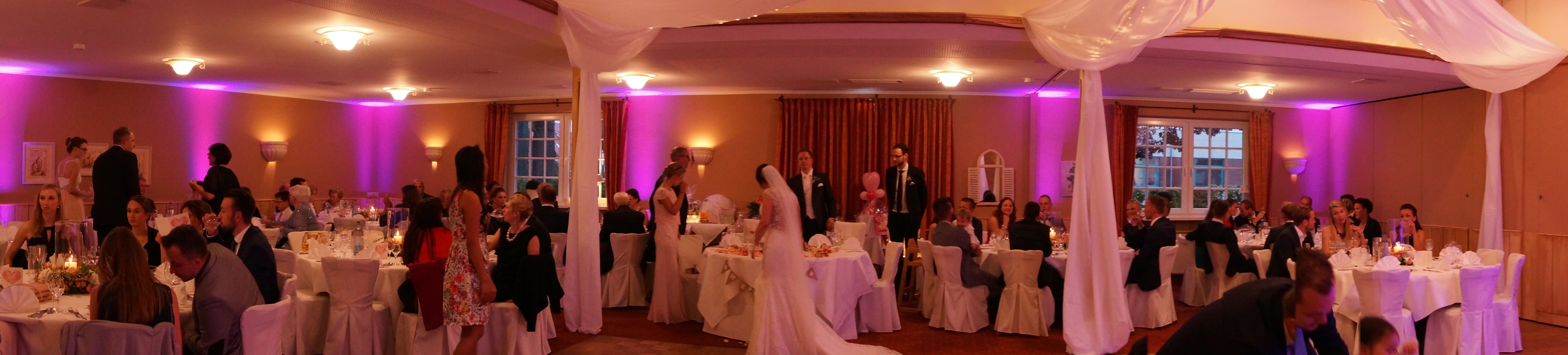 Hochzeitssaal mit Brautpaar und Gästen