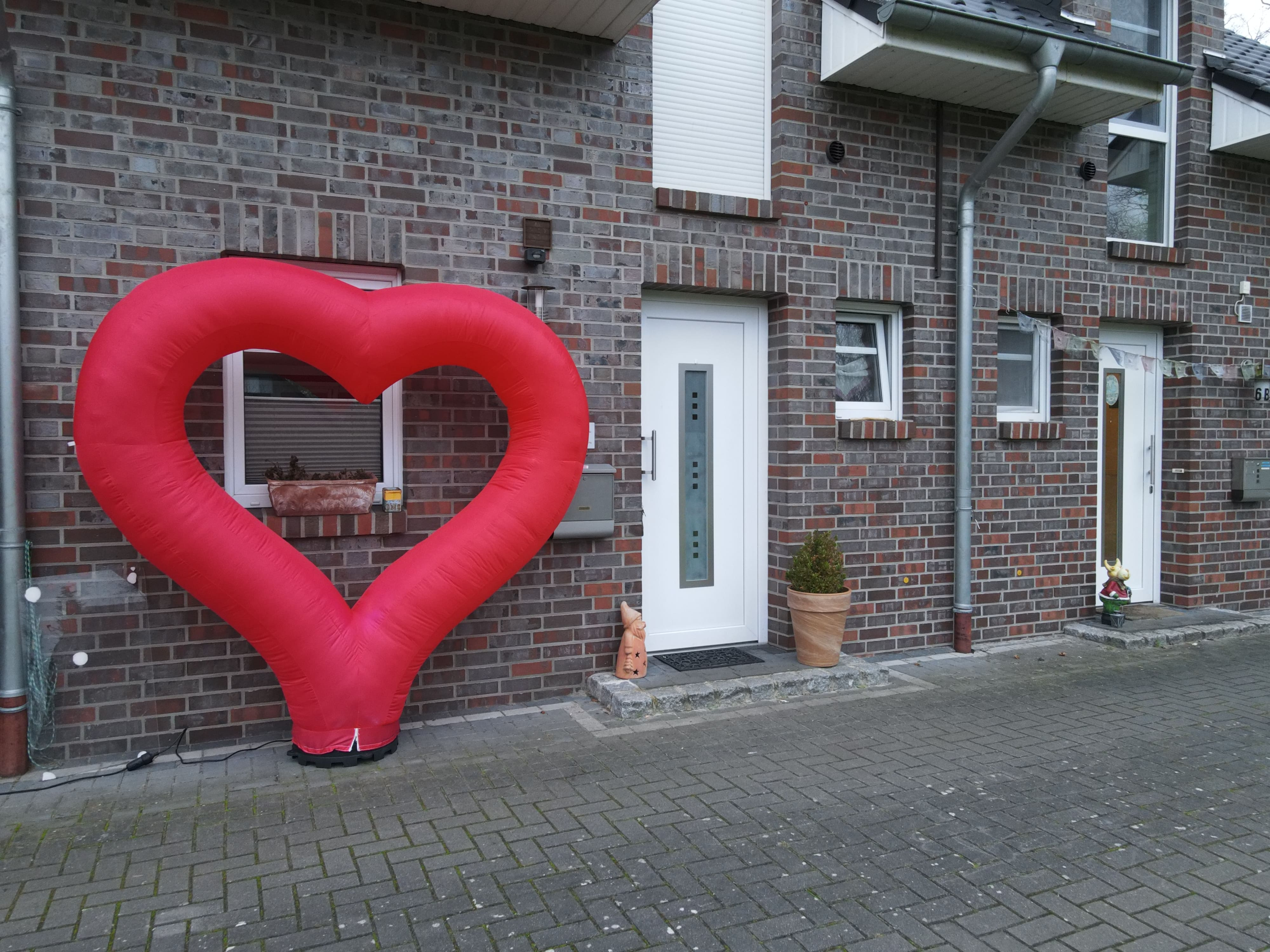 Großes rotes Luftherz vor Hauswand
