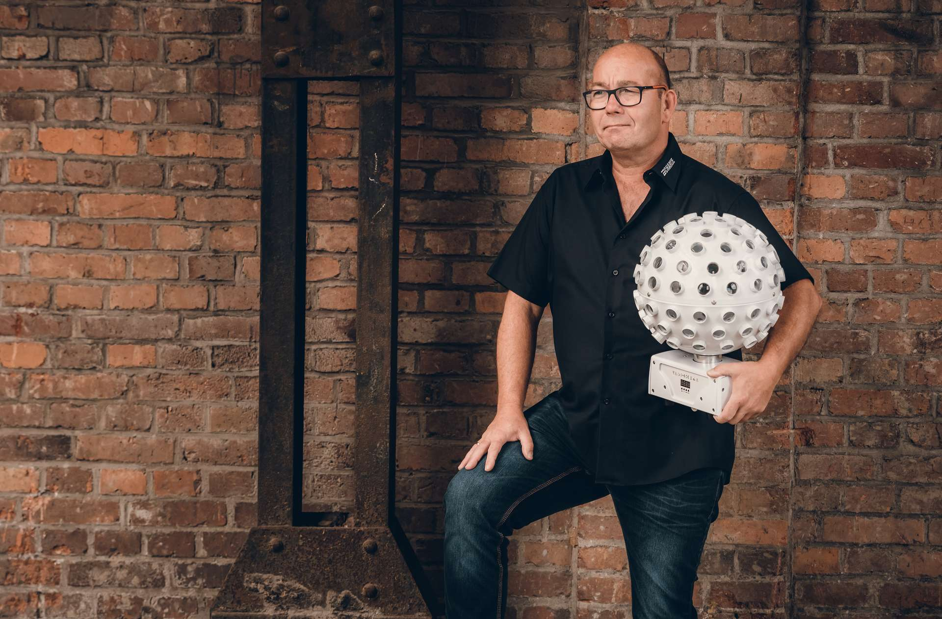 Bild von DJ Charlie mit Discokugel im Arm